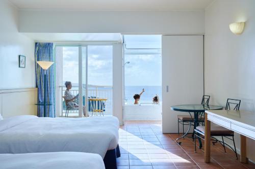 a hotel room with two beds and a view of the ocean at Hoshino Resorts RISONARE Guam in Tamuning