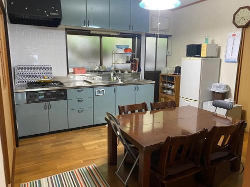 a kitchen with a table and a kitchen with a refrigerator at HANAMIDORI Sugata Hotaru no Sato - Vacation STAY 16201 in Gujo