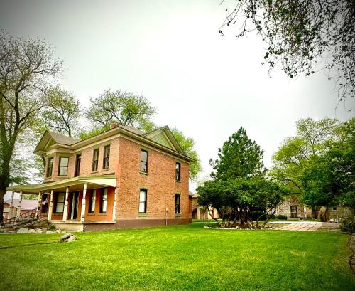 a large brick house on a green lawn at The Second Story in Raton