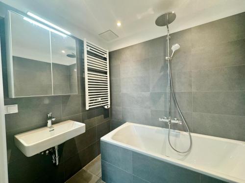 ein Badezimmer mit einer Dusche, einem Waschbecken und einer Badewanne in der Unterkunft Modern Premium Apartment with Balcony in Wien