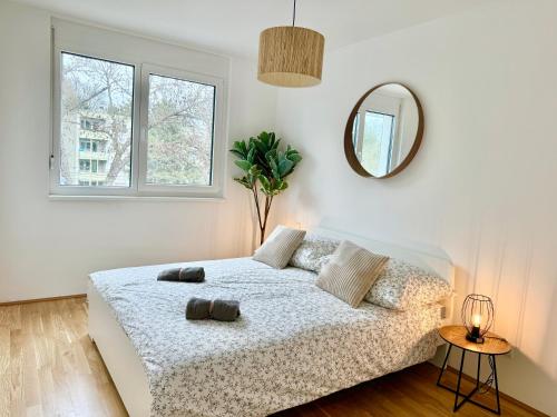 um quarto branco com uma cama e um espelho em Modern Premium Apartment with Balcony em Viena