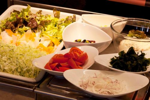 a tray filled with bowls of different types of vegetables at Kumamoto Washington Hotel Plaza in Kumamoto