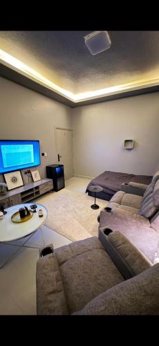 a living room with a couch and a tv at شقة استديو حي المغرزات in Riyadh