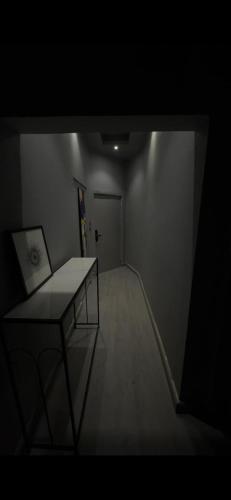 a dark room with a table and a hallway at شقة استديو حي المغرزات in Riyadh