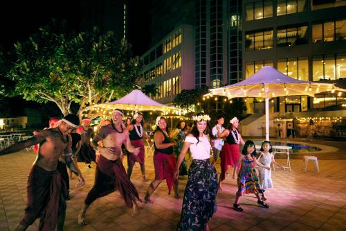 a group of people dancing on a street at night at Hoshino Resorts RISONARE Guam in Tamuning