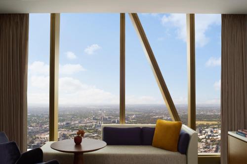 a living room with a couch in front of a large window at The Ritz-Carlton, Melbourne in Melbourne