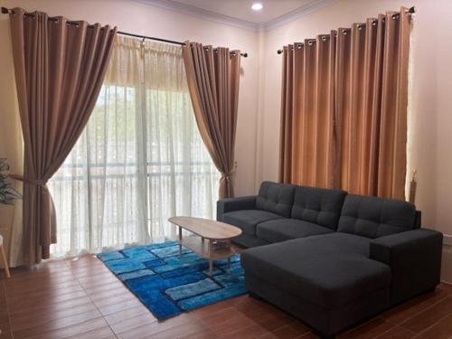 a living room with a couch and a large window at A'yn Homestay in Bandar Seri Begawan