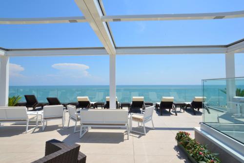 a patio with a table and chairs on a balcony at Grande Albergo Marin in Lignano Sabbiadoro