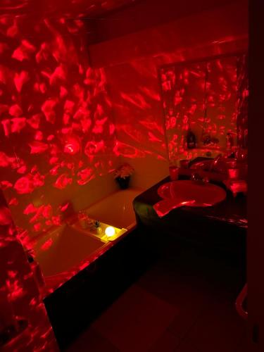 Baño rojo con bañera, lavabo y rosas rojas en Havre de Paix parking inclus, en Carquefou