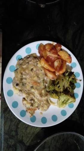 a plate of food with rice and broccoli on a table at Hospedaje Valencia Osa, CR in Potrero