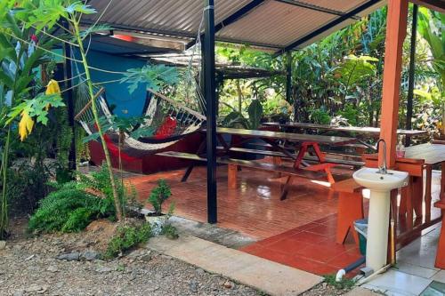 a porch with a hammock and a table at Hospedaje Valencia Osa, CR in Potrero