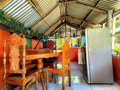 uma cozinha com uma mesa de madeira e um frigorífico em A. Zaragosa Lodging House em San Vicente