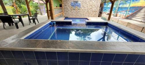 a swimming pool with blue tile in a house at Finca los tucanes in Villamaría