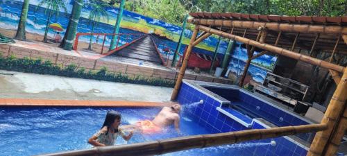 a girl and a dog in a swimming pool at Finca los tucanes in Villamaría