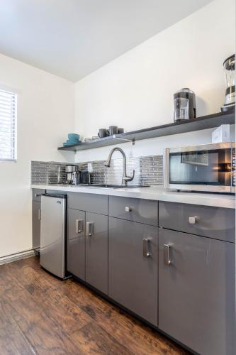 a kitchen with stainless steel cabinets and a sink at Aqua Soleil Hotel and Mineral Water Spa in Desert Hot Springs