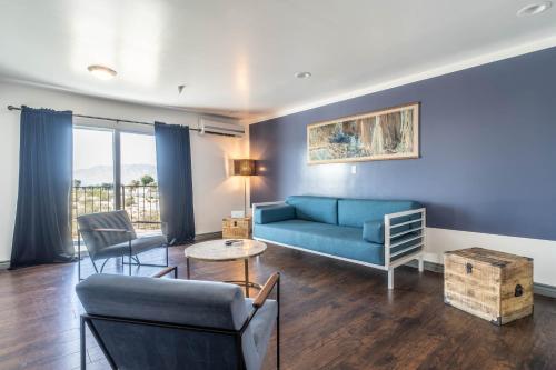a living room with a blue couch and chairs at Aqua Soleil Hotel and Mineral Water Spa in Desert Hot Springs