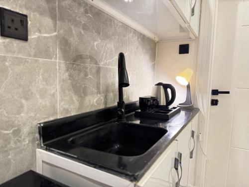 una cucina con lavandino nero in una stanza di Apartment on city a Riyad