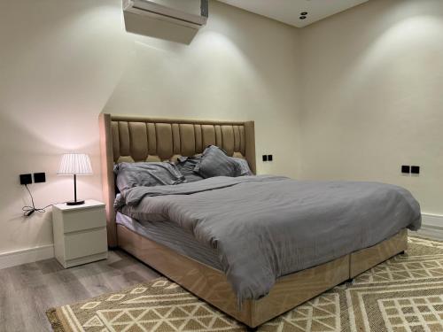 una camera con un grande letto e una lampada di Apartment on city a Riyad