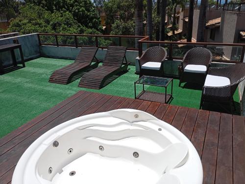 皮帕Pipa beleza SPA Resort_Chalé Duplex/Jacuzzi的甲板上的按摩浴缸,配有椅子