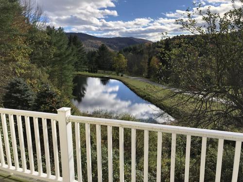 a white fence with a view of a river at Silver Spring Chalet home in Pittsfield