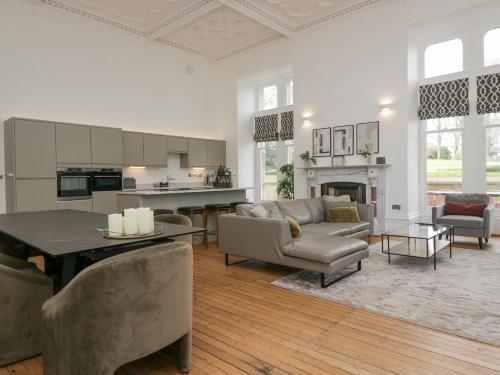 een woonkamer met een bank en een tafel bij The Myles Suite Stone Cross Mansion in Ulverston