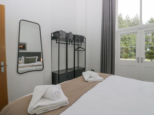 een slaapkamer met een bed met een spiegel aan de muur bij The Myles Suite Stone Cross Mansion in Ulverston
