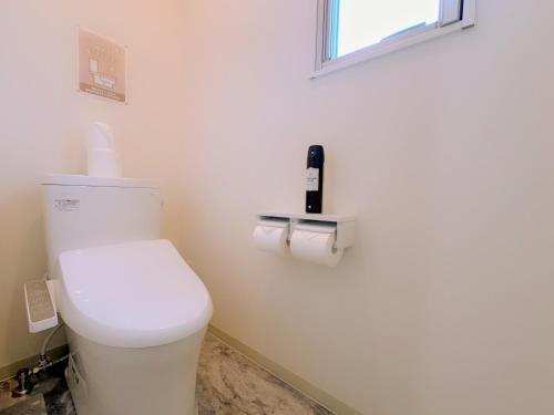 a bathroom with a white toilet and a window at Necoana Glamping Annovillasグランピング in Fujikawaguchiko