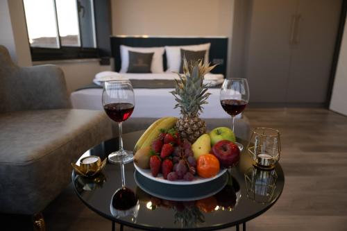 a table with a bowl of fruit and two glasses of wine at Swans Hotel Old City Grand Bazaar in Istanbul