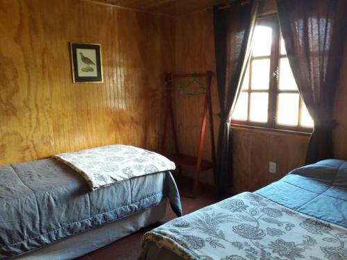 1 dormitorio con cama y ventana en Acogedora cabaña para disfrutar y descansar, en Olmué
