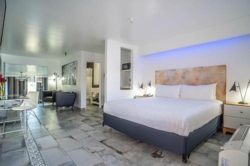 a bedroom with a large bed and a living room at Aqua Soleil Hotel and Mineral Water Spa in Desert Hot Springs