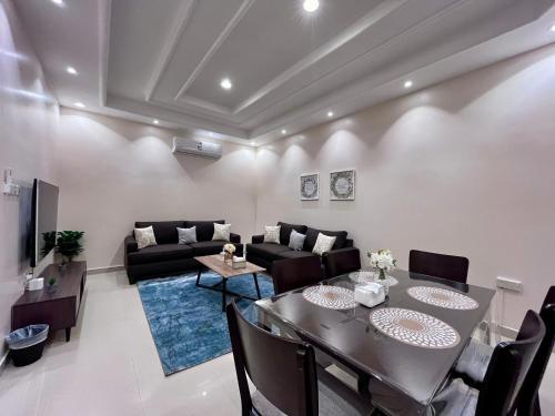 a living room with a black couch and a table at شقق نسج المسكن دخول ذاتي شمال الرياض in Riyadh
