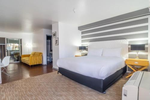 a bedroom with a large bed and a living room at Aqua Soleil Hotel and Mineral Water Spa in Desert Hot Springs