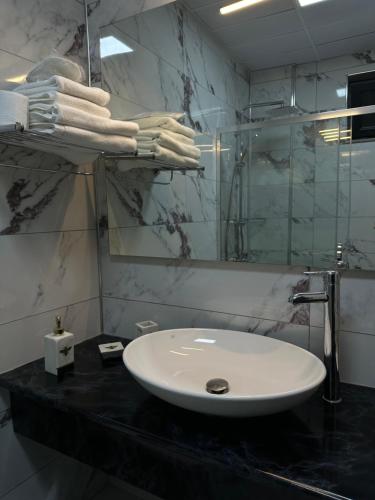 a bathroom with a white sink and a mirror at AGİOS HOTEL in Gokceada Town