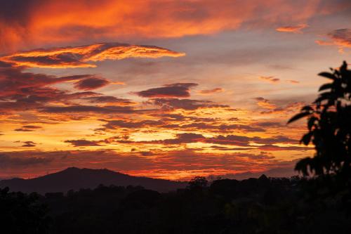 a sunset with a mountain in the background at Victoria´s House in Grecia