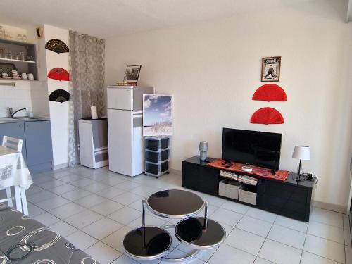 - une cuisine avec 2 chaises et une télévision dans la chambre dans l'établissement Banyuls-sur-Mer: T2 avec terrasse couverte et parking privatif - FR-1-309-146, à Banyuls-sur-Mer