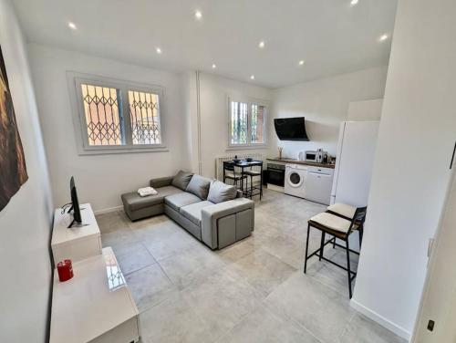 a living room with a couch and a kitchen at Excellent T2 - Moderne & Tout Equipé avec Parking in Grenoble