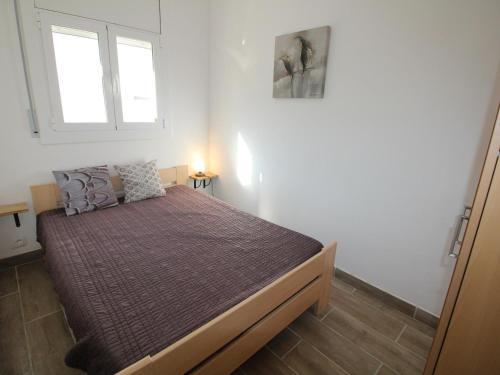 Apartamento Llançà, 1 dormitorio, 4 personas - ES-228-86 في يانسا: غرفة نوم بسرير كبير مع نافذة