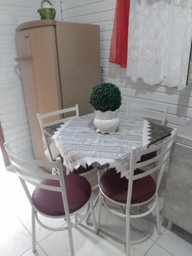 a table with two chairs and a table with a plant on it at Casa barra velha sc in Barra Velha