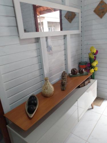 a shelf in a room with a mirror and vases at Casa barra velha sc in Barra Velha