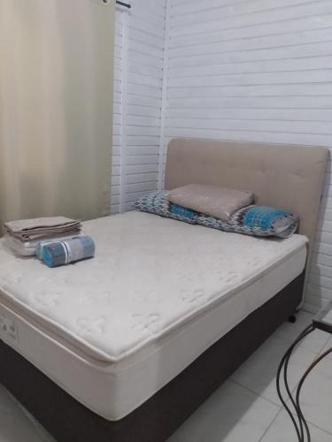 a white bed with two pillows on top of it at Casa barra velha sc in Barra Velha