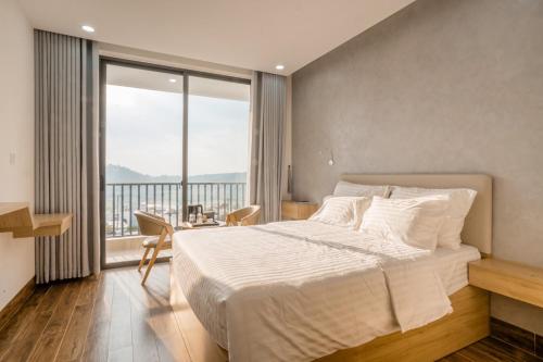 una camera con un grande letto e una grande finestra di Diora Hotel a Pleiku