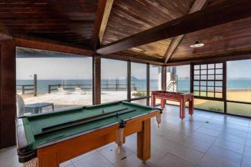 a pool table in a room with a view of the beach at Casa Buzios resort in Búzios