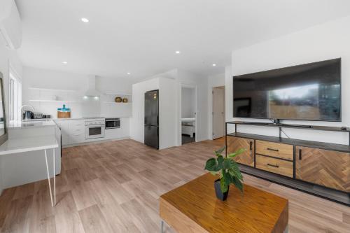 a kitchen and living room with a large screen tv at Close to Town & Lake - Taupo in Taupo