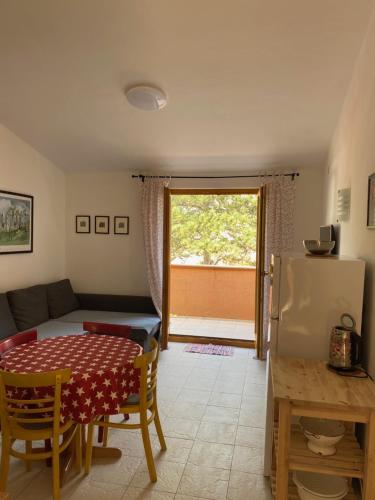 a kitchen and living room with a table and a refrigerator at Apartments Lili in Baška