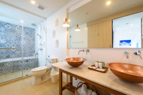 La salle de bains est pourvue d'un lavabo en cuivre et de toilettes. dans l'établissement Costa Village Jacuzzi Bangsaray, à Bang Sare