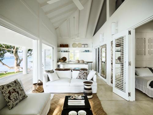 uma sala de estar com um sofá branco e uma cama em Tamarind Beach Estate em Port Vila