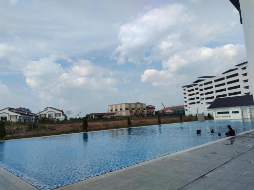 uma grande piscina em frente a alguns edifícios em Homestay Ijan em Cyberjaya