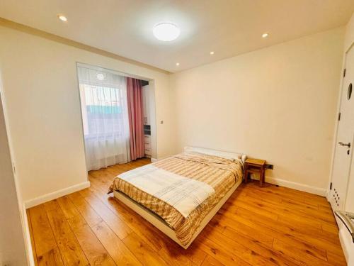 Un dormitorio con una cama y suelo de madera. en City Apartment Home, en Ulán Bator