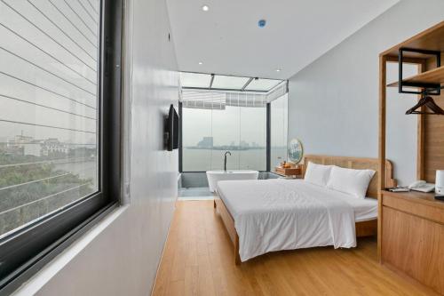 a bedroom with a bed and a bath tub and a window at Lakeview Residence Hotel in Hanoi