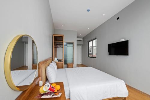 a bedroom with a white bed and a mirror at Lakeview Residence Hotel in Hanoi